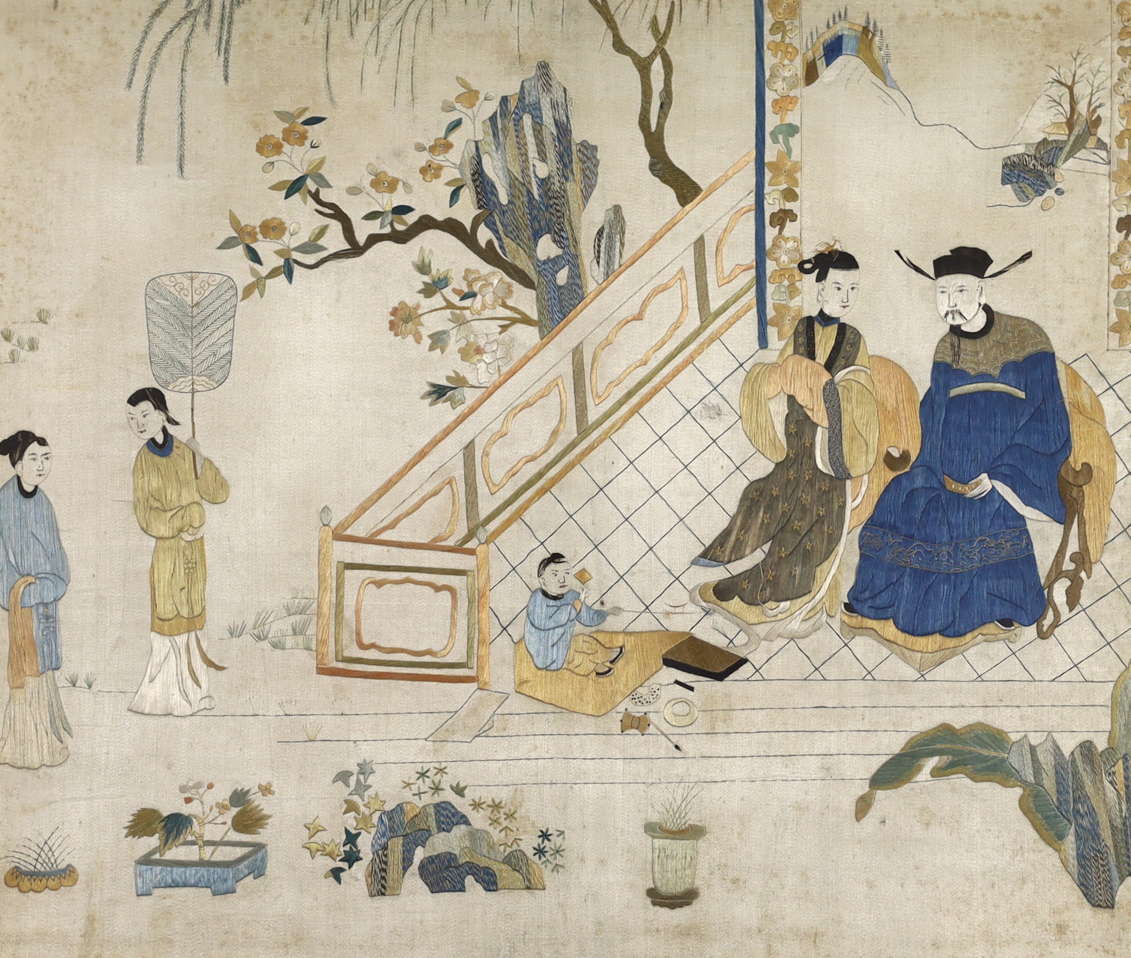 An early 19th century Chinese finely embroidered silk picture, of a nobleman, his wife and child and their attendants. Possibly a court scene. Worked mainly in stem stitch, in golds, blues, greens and white.